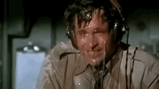 A Man Wearing Headphones Is Sweating While Sitting In A Plane . GIF