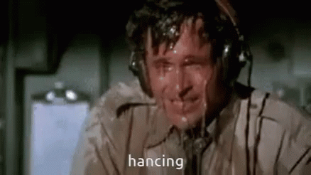 A Man Wearing Headphones Is Sweating While Talking On A Phone And The Word Hanging Is Written On The Screen . GIF
