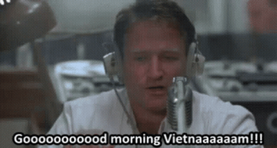 A Man Wearing Headphones Is Talking Into A Microphone And Saying Good Morning Vietnam . GIF