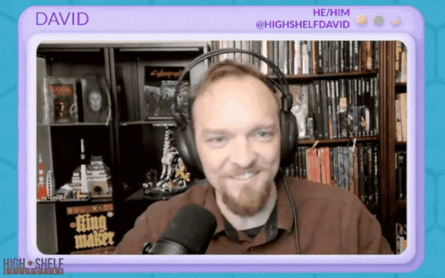 A Man Wearing Headphones Is Talking Into A Microphone And The Name David Is On The Screen Behind Him GIF