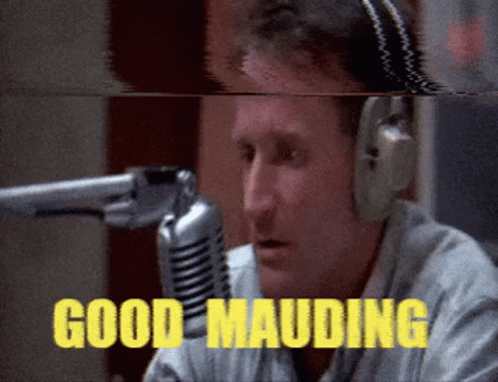 A Man Wearing Headphones Is Talking Into A Microphone And The Words Good Mauding Are Visible GIF