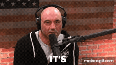 A Man Wearing Headphones Is Talking Into A Microphone And The Words It 'S Are On The Screen Behind Him GIF