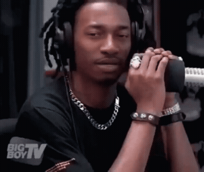 A Man Wearing Headphones Is Talking Into A Microphone With A Big Boy Tv Logo Behind Him GIF
