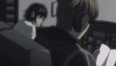 A Man Wearing Headphones Is Talking To Another Man In A Dark Room GIF