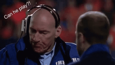 A Man Wearing Headphones Is Talking To Another Man On A Field . GIF