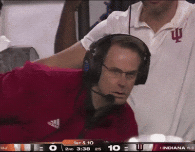 A Man Wearing Headphones Is Watching A Football Game Between Indiana And Iowa GIF