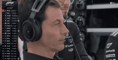 A Man Wearing Headphones Is Watching A Race On A Tv Screen GIF