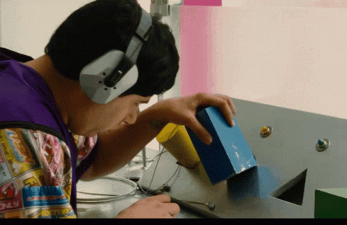 A Man Wearing Headphones Looks At A Blue Box That Says Candy Only On It GIF