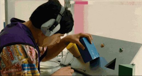 A Man Wearing Headphones Looks At A Monopoly Board Game GIF