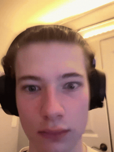 A Man Wearing Headphones Looks At The Camera GIF