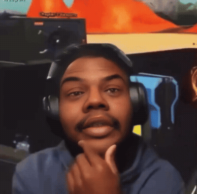 A Man Wearing Headphones Looks At The Camera With A Sign In The Background That Says ' Captain League ' GIF