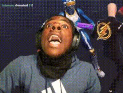 A Man Wearing Headphones Looks Up At A Statue Of A Superhero GIF