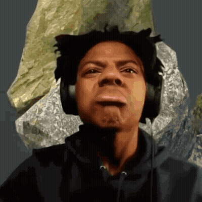 A Man Wearing Headphones Making A Funny Face In Front Of A Rock GIF