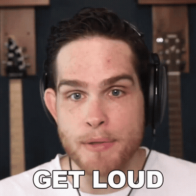 A Man Wearing Headphones Says " Get Loud " In Front Of A Guitar GIF