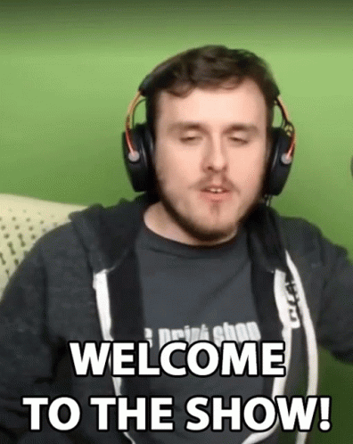 A Man Wearing Headphones Says Welcome To The Show While Sitting On A Couch GIF