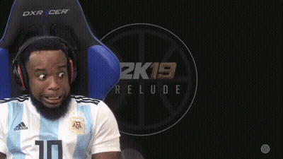 A Man Wearing Headphones Sits In A Chair With A 2K19 Relude Logo Behind Him GIF