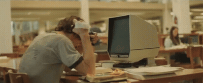 A Man Wearing Headphones Sits In Front Of A Computer Monitor GIF