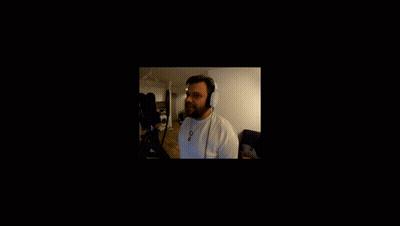 A Man Wearing Headphones Stands In Front Of A Black Screen GIF