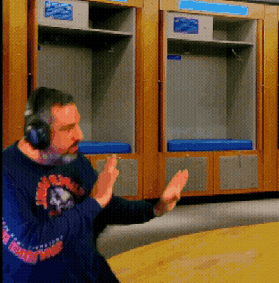 A Man Wearing Headphones Stands In Front Of A Locker Room With A Blue Cushion GIF