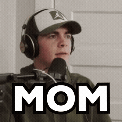 A Man Wearing Headphones Stands In Front Of A Microphone And Says Mom GIF