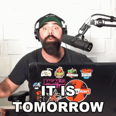 A Man Wearing Headphones Stands In Front Of A Microphone With A Laptop That Says It Is Tomorrow GIF