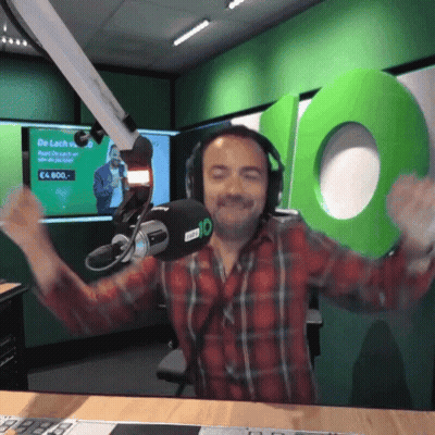 A Man Wearing Headphones Stands In Front Of A Microphone With The Number 10 Behind Him GIF