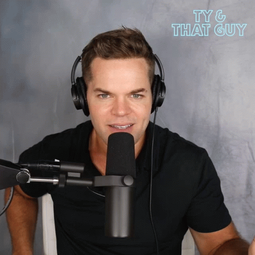A Man Wearing Headphones Stands In Front Of A Microphone With The Words Ty & That Guy Written Above Him GIF