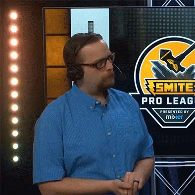 A Man Wearing Headphones Stands In Front Of A Screen That Says Smite Pro Leag Presented By Mixer GIF