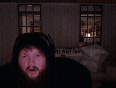 A Man Wearing Headphones Stands In Front Of A Sign That Says " Part Per In My Pant " GIF