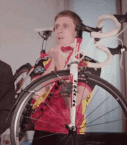 A Man Wearing Headphones Stands Next To A Bike With The Word Trek On It GIF
