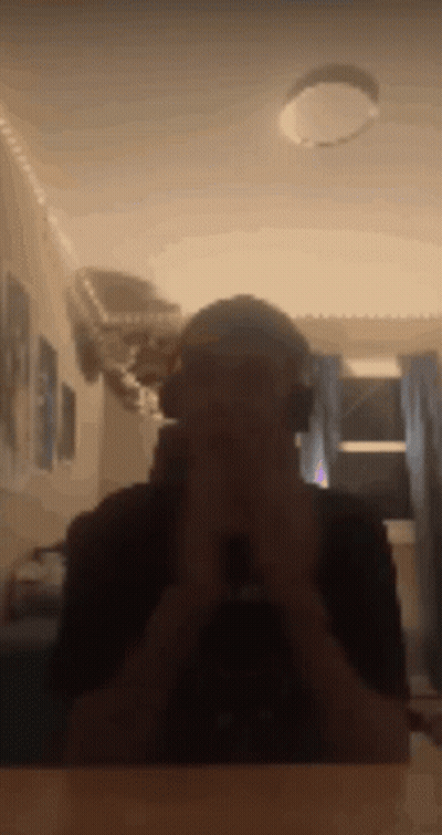 A Man Wearing Headphones Takes A Picture Of Himself In A Mirror . GIF