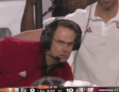 A Man Wearing Headphones Watches A Football Game Between Indiana And Ucsd GIF