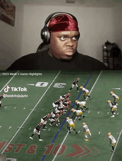 A Man Wearing Headphones Watches A Football Game On Tiktok GIF