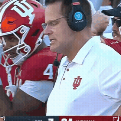 A Man Wearing Headphones Watches A Football Game With A Player Wearing Number 4 GIF