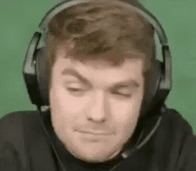 A Man Wearing Headphones With A Microphone On His Head Is Making A Funny Face . GIF