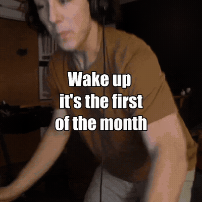 A Man Wearing Headphones With The Words Wake Up It 'S The First Of The Month GIF