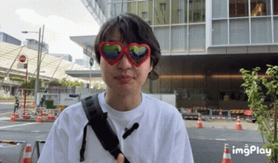 A Man Wearing Heart Shaped Sunglasses And A Backpack GIF
