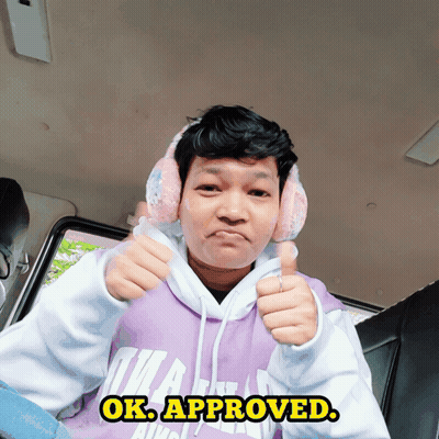 A Man Wearing Pink Ear Muffs And A Purple Hoodie Giving A Thumbs Up Sign GIF