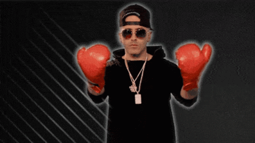 A Man Wearing Red Boxing Gloves And A Necklace With A Tag That Says ' A ' On It GIF