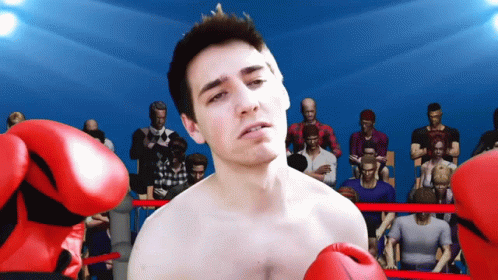 A Man Wearing Red Boxing Gloves Is Standing In A Ring GIF