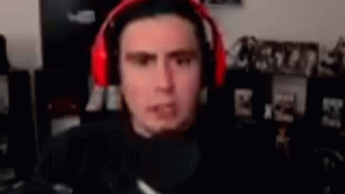 A Man Wearing Red Headphones Is Sitting In Front Of A Microphone . GIF