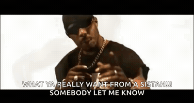 A Man Wearing Sunglasses , A Hat , And A Chain Is Holding A Gun . GIF
