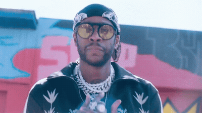 A Man Wearing Sunglasses And A Bandana Is Standing In Front Of A Wall With The Number 5 On It GIF