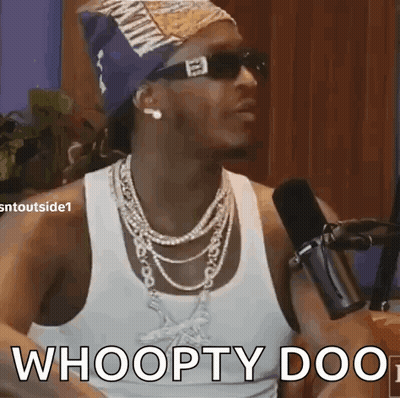 A Man Wearing Sunglasses And A Bandana Is Talking Into A Microphone . GIF