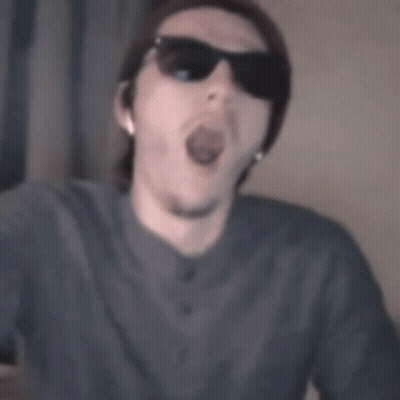 A Man Wearing Sunglasses And A Beanie Is Making A Funny Face GIF