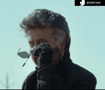 A Man Wearing Sunglasses And A Black Jacket Is Talking On A Cell Phone With A Twitter Logo In The Corner GIF