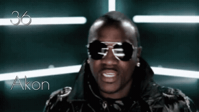 A Man Wearing Sunglasses And A Black Jacket With The Name Akon Written On The Bottom GIF