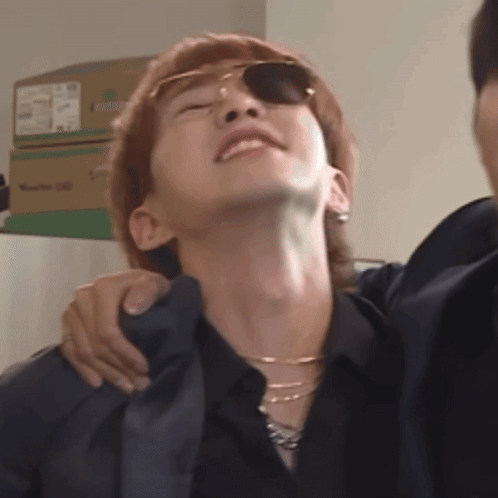 A Man Wearing Sunglasses And A Black Shirt Is Being Held By Another Man GIF