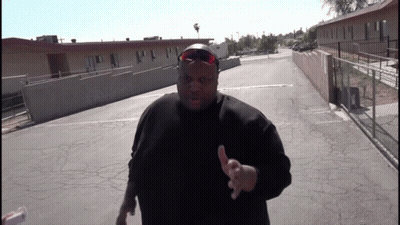 A Man Wearing Sunglasses And A Black Shirt Is Giving A Thumbs Up Sign GIF