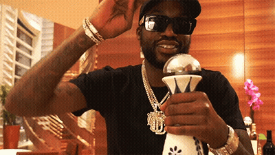 A Man Wearing Sunglasses And A Black Shirt Is Holding A Silver Object GIF